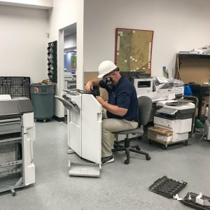 Office Systems team member repairing a copier