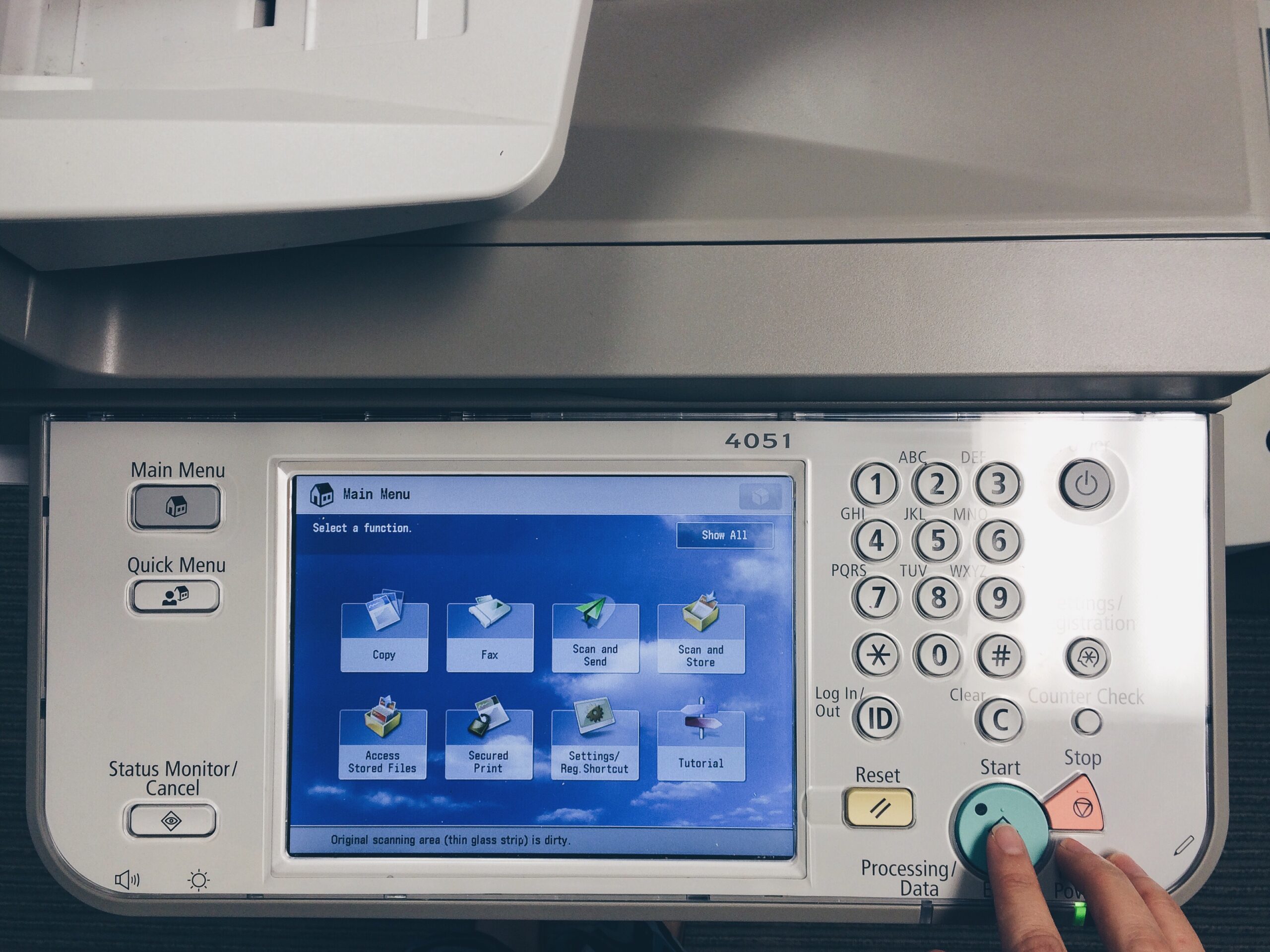 Worker pressing start on a printer