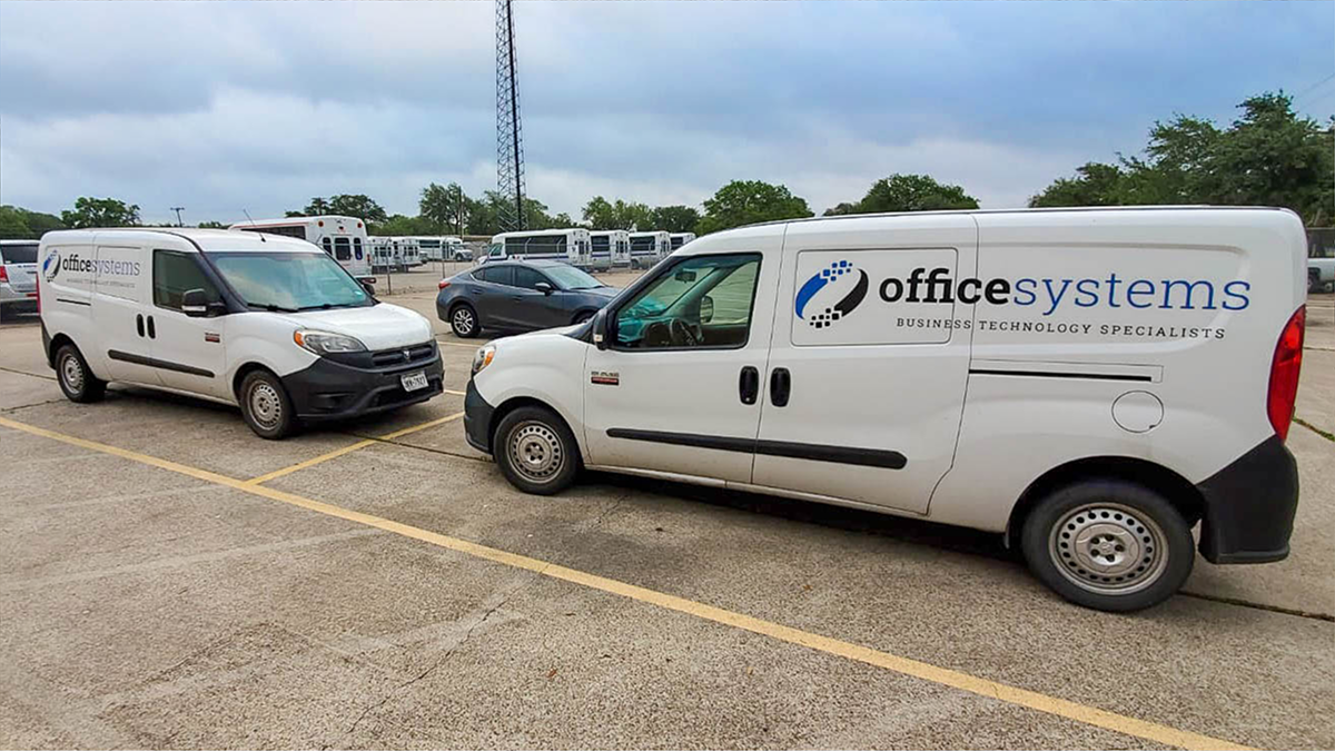 A white delivery van with "officesystems" logo parked in a lot.